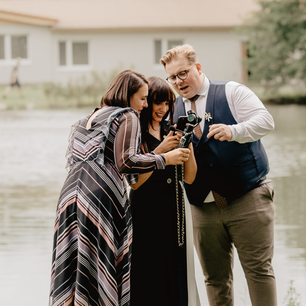 a group of people standing next to a body of water