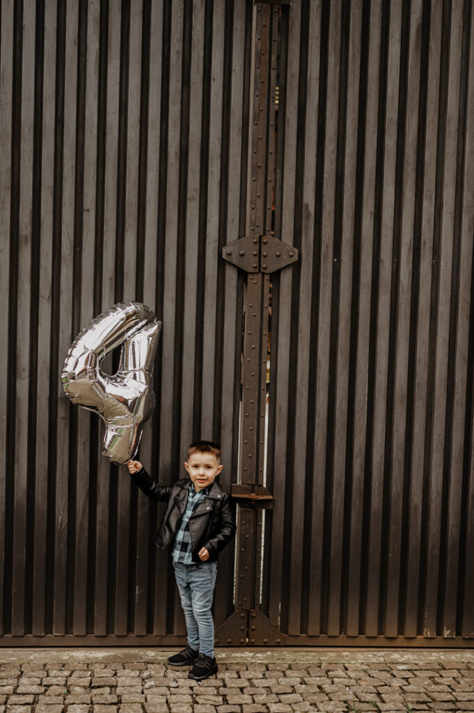 a boy holding a silver balloon