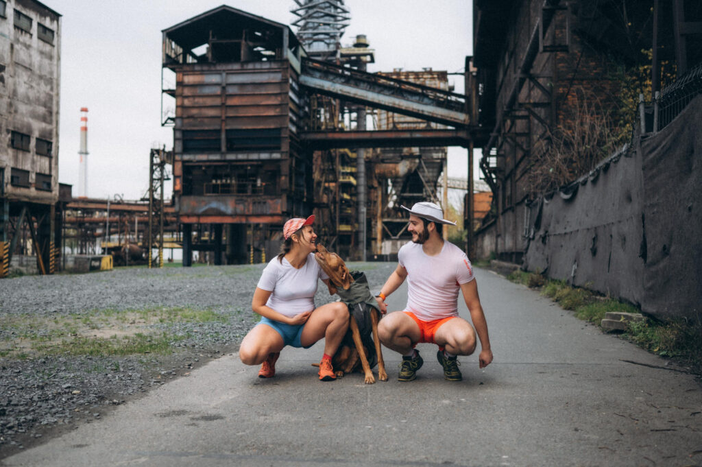 a man and woman kneeling with a dog